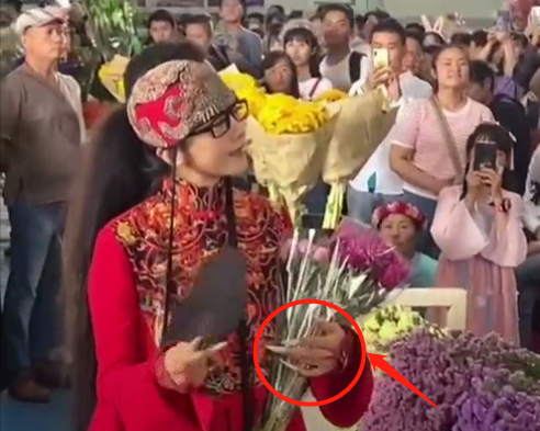 63岁杨丽萍逛花市被拍 男伴贴心为其提袖子